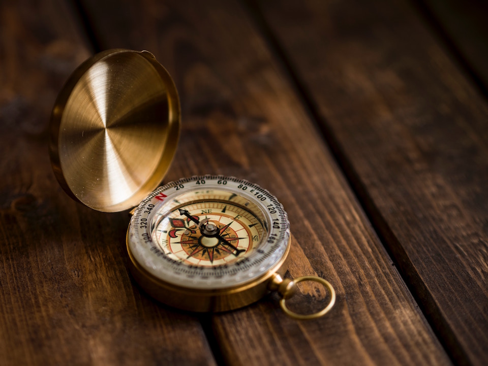 Golden compass on a hardwood table