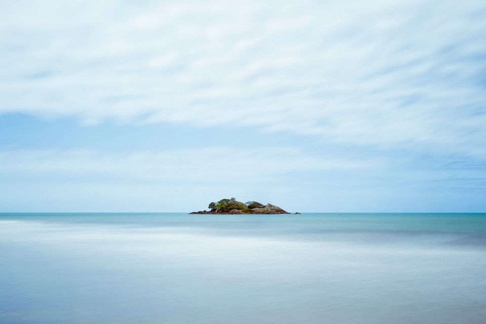 Small island in the middle of the blue waters