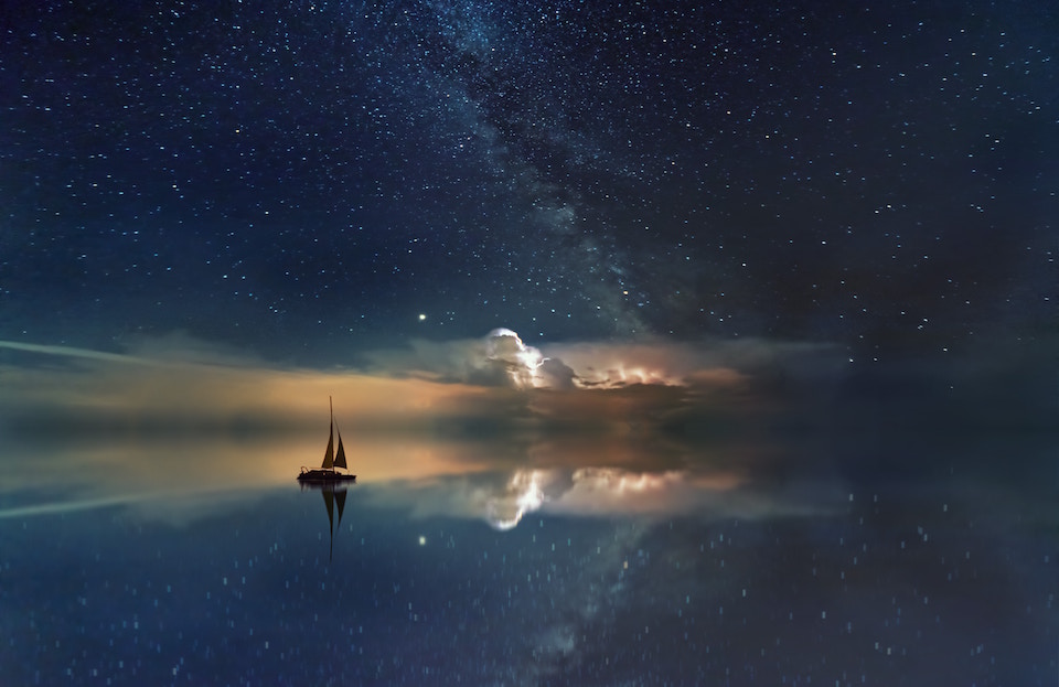 Small ship sailing in a starry background