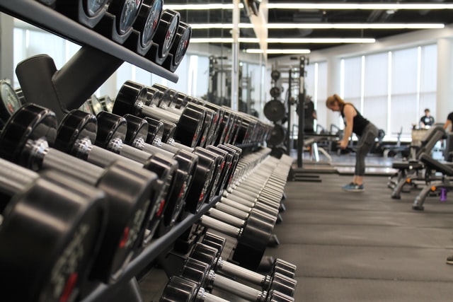 Woman standing surrounded by exercise equipment