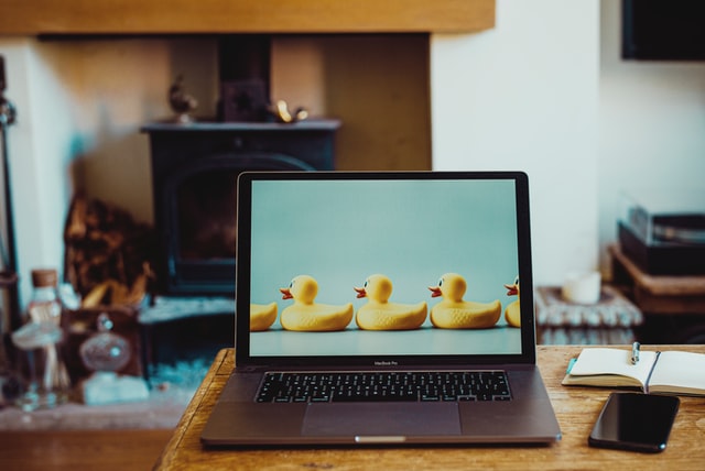 MacBook Pro on brown wooden table